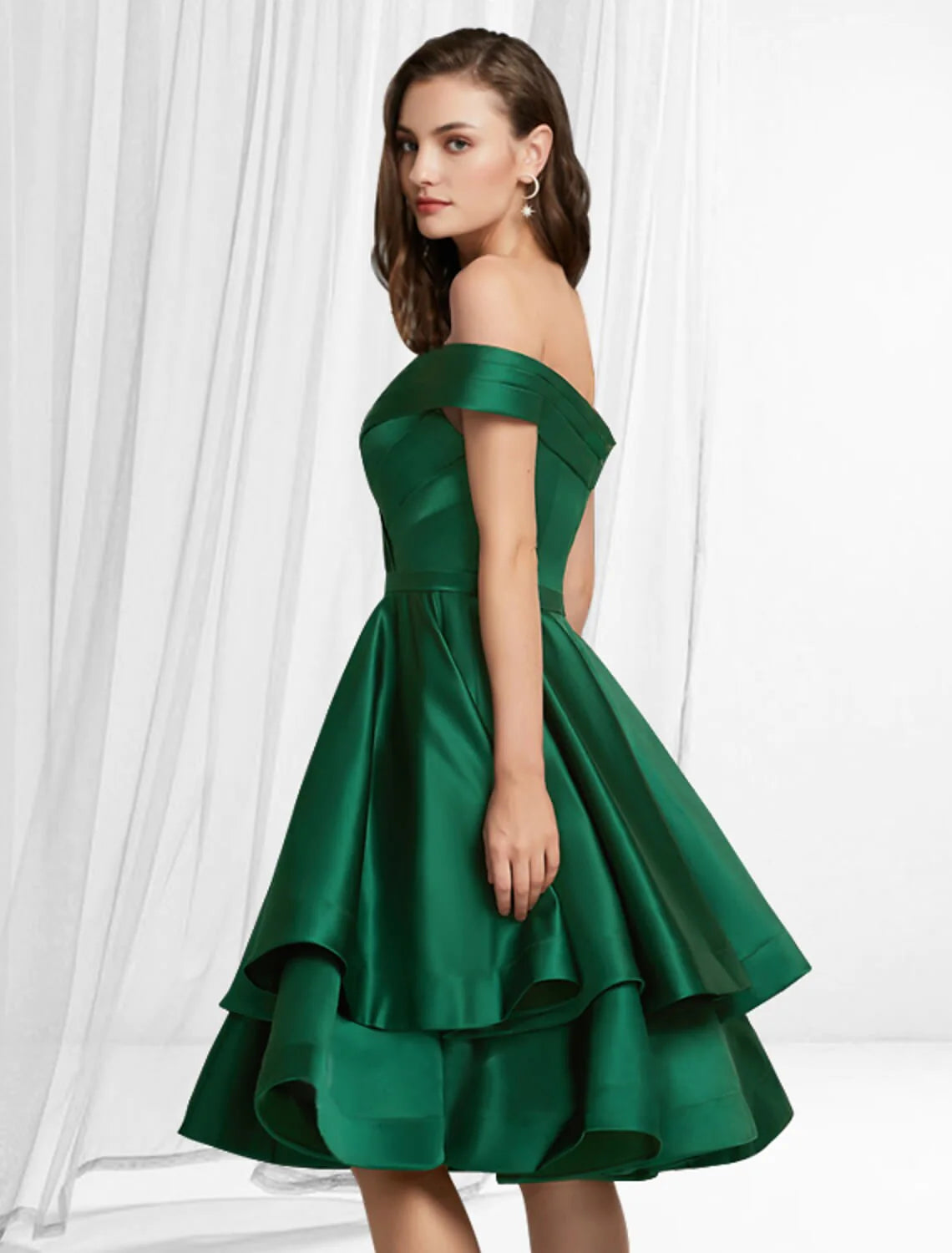 Detail view of the tiered satin fabric and knee-length design of the off-shoulder party dress.