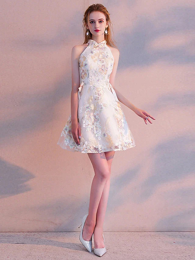 Close-up of the floral embroidery and sash ribbon on the two-piece A-line mini cocktail dress.