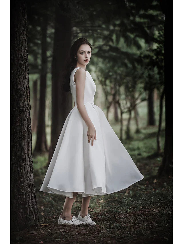 Full length view of the white A-line tea length wedding dress on a model, displaying its overall design.