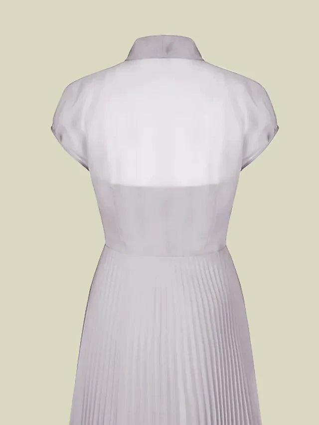 Close-up of the dress's jewel neck, short sleeve, and bow embellishment.