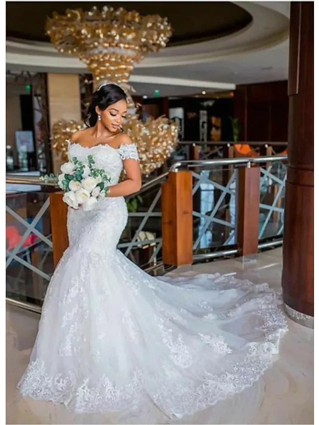 Close-up of delicate lace appliques and off-shoulder neckline on a wedding dress.