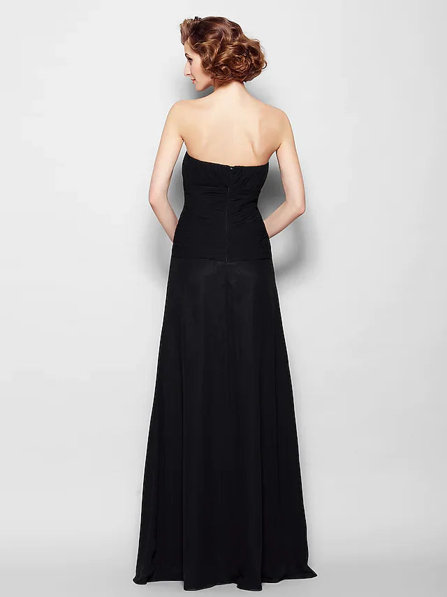 Back view of an A-line strapless chiffon gown with flowing skirt and ruched details, worn by a woman at a formal event.
