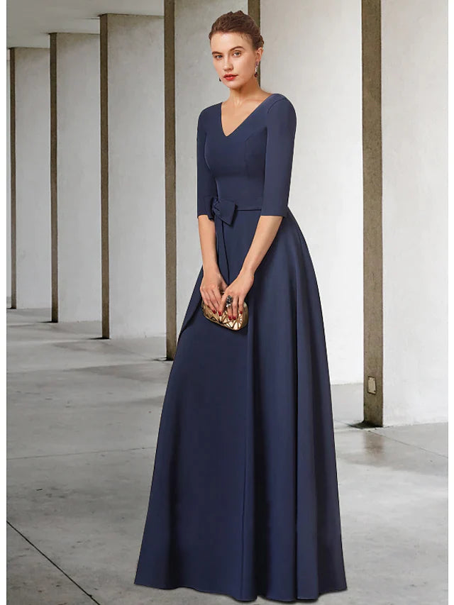 Sophisticated dark blue mother of the bride dress with a V-neck, half sleeves, and a flowing pleated skirt.