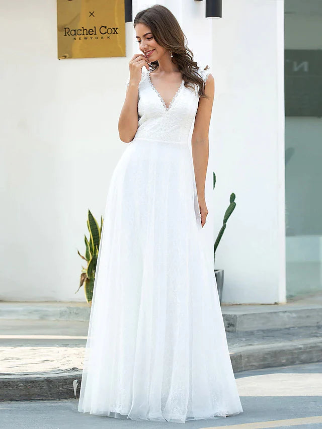 Model posing gracefully in an A-line V-neck short sleeve lace tulle wedding dress.