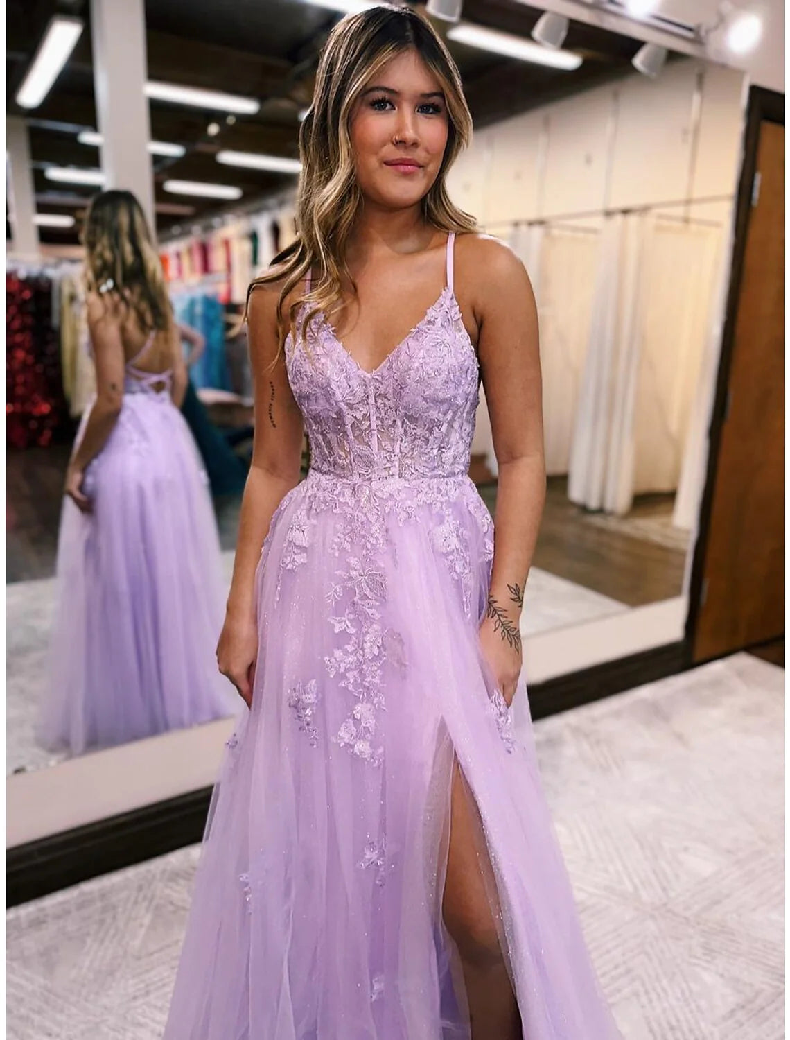 Model showcasing light blue A-line sleeveless evening dress with flowing skirt.