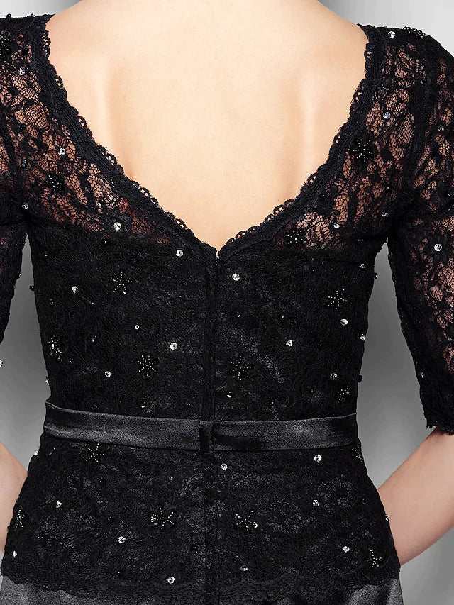 Woman in a sophisticated navy blue V-neck dress, suitable for a wedding or special event.
