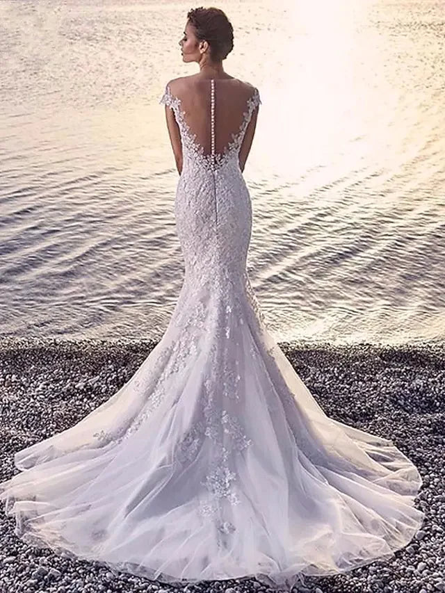 Back view of a model wearing the white organza wedding dress, showcasing the court train and delicate appliques.