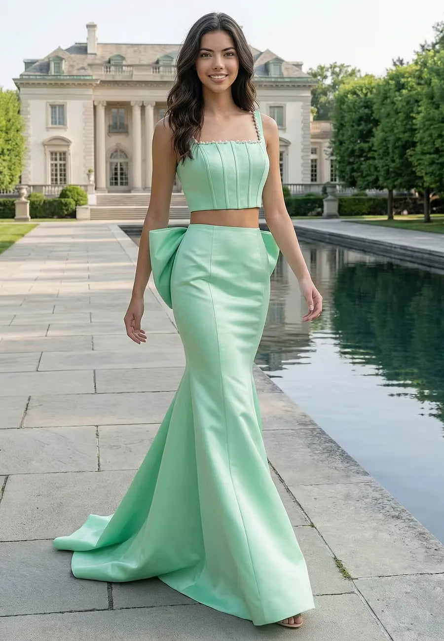 Side view of the two-piece mint green satin prom dress, showing the fitted mermaid skirt and crop top with pearl straps.