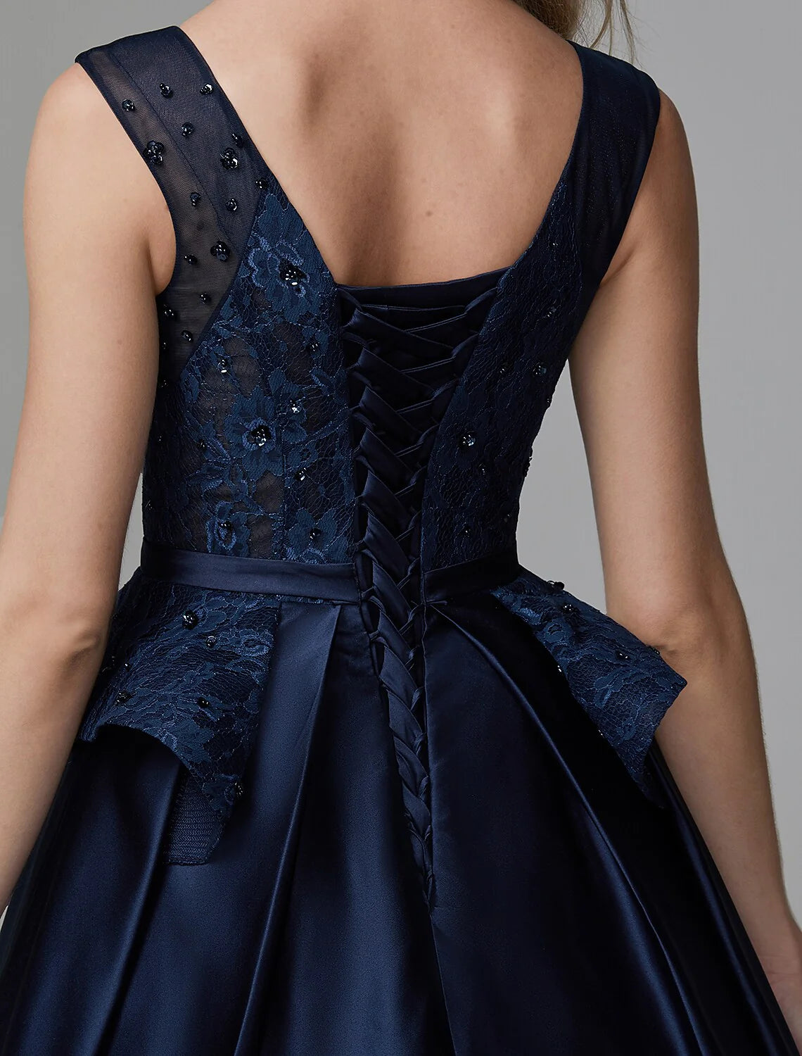 Model posing in the elegant ball gown, showing the full design.