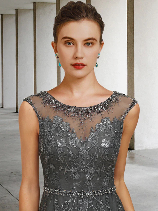 Close-up of the lace tulle fabric with intricate beading and sequin details on the dress.