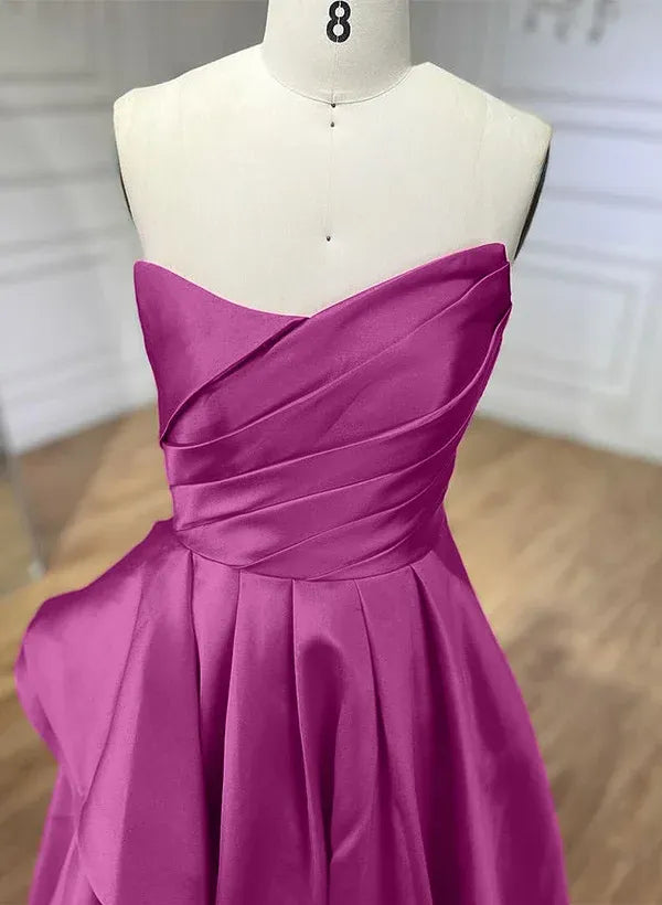 Full-length view of a model posing in a magenta A-line strapless pleated ruffled satin prom dress.