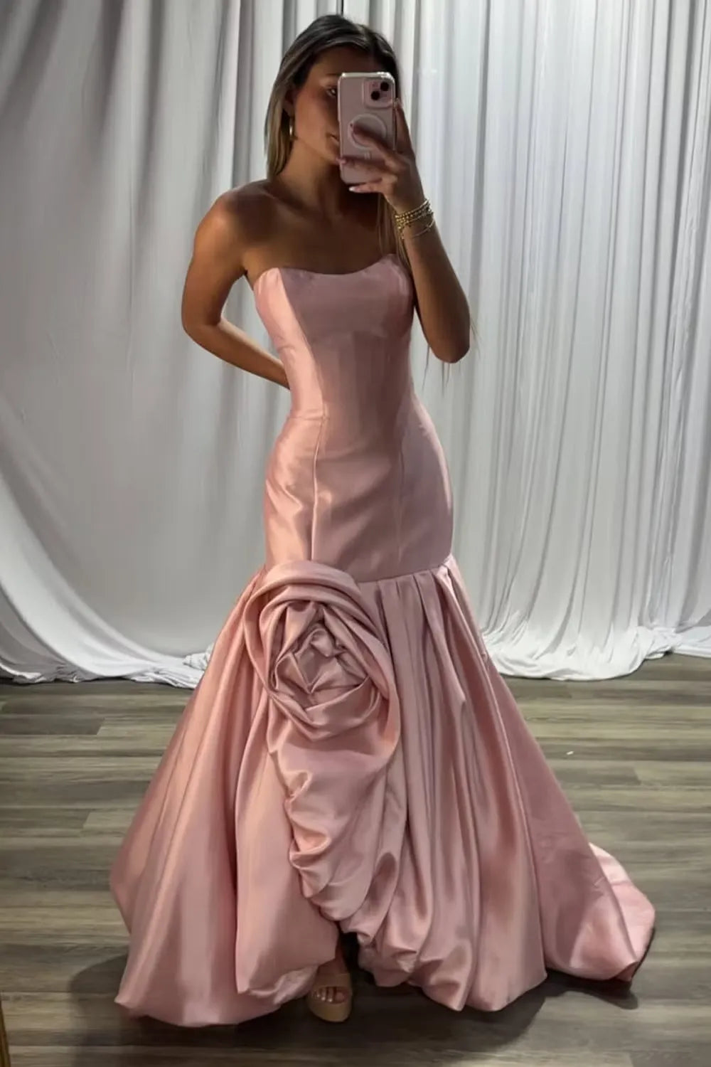 Full-length view of a woman posing in the elegant pink strapless mermaid gown.