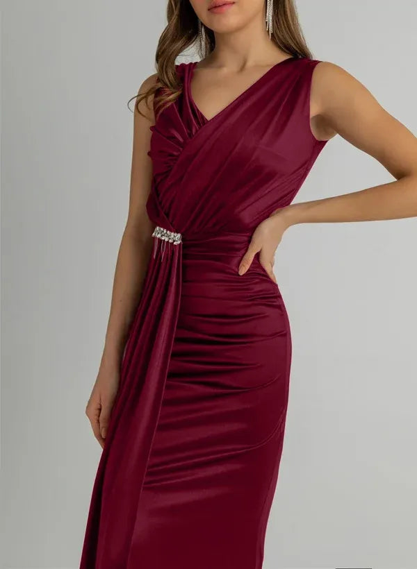 Front view of a model in a sleeveless burgundy mermaid dress, highlighting the ruched bodice.