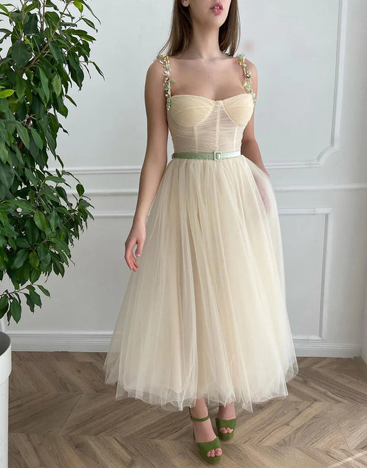 Front view of an apricot A-line tulle homecoming dress with intricate beading on the bodice.