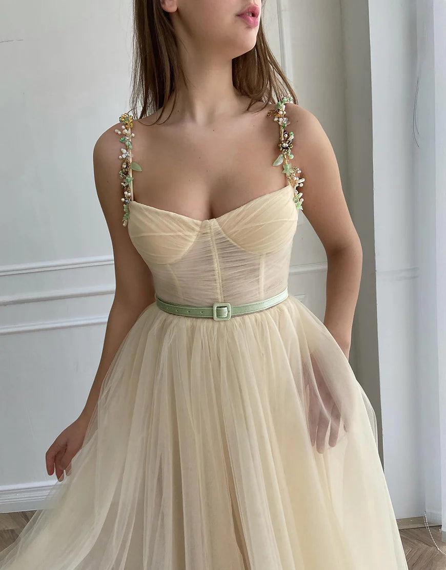 Side view of a model wearing the apricot A-line tulle homecoming dress, showcasing its flowing skirt.