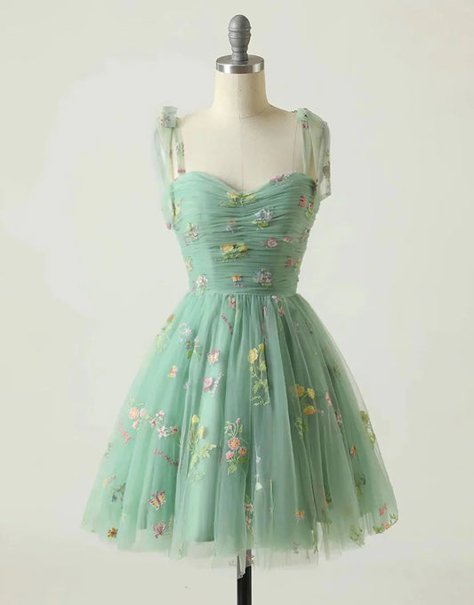 Model wearing a short A-line green homecoming dress with a sweetheart neckline.