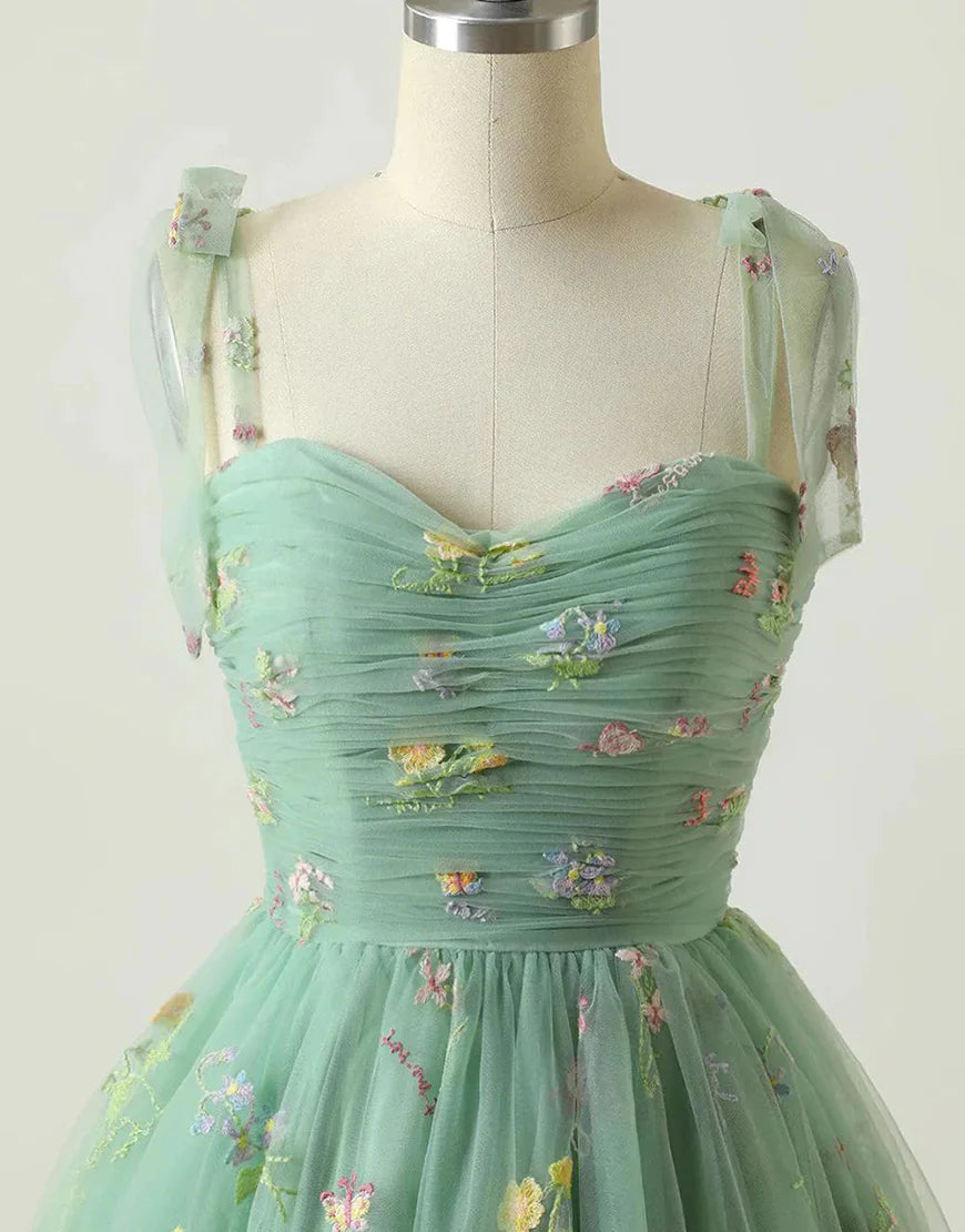 Model posing in a short A-line green homecoming dress.