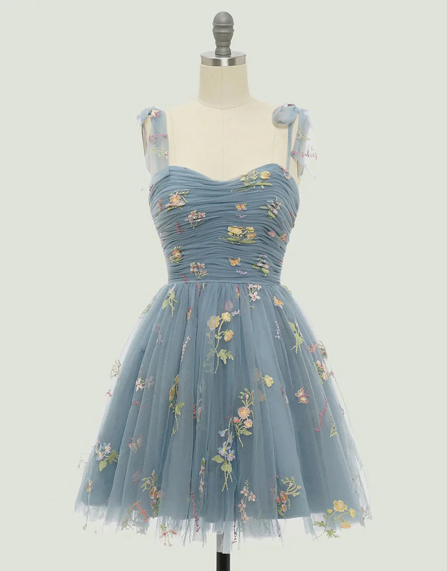 Model wearing a short A-line blue homecoming dress with a sweetheart neckline.