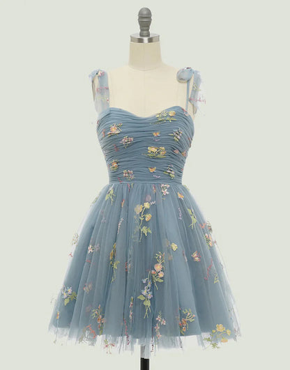 Model wearing a short A-line blue homecoming dress with a sweetheart neckline.