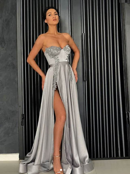 Woman wearing an elegant dark A-line off-shoulder satin prom dress with a high slit.
