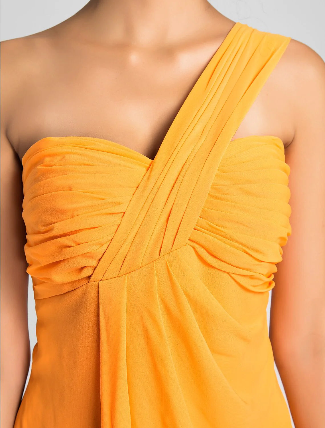 Side view of a model in a light blue A-line one-shoulder knee-length dress.