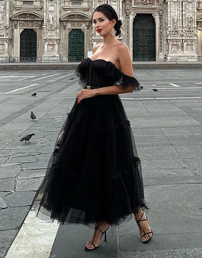 Black off-shoulder A-line tulle homecoming dress, front view.