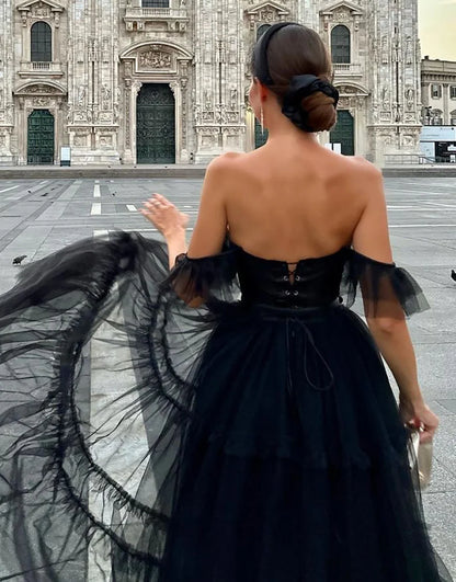 Black off-shoulder A-line tulle homecoming dress, side view.