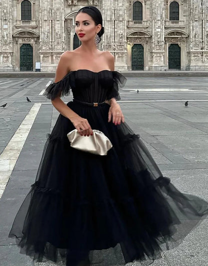 Black off-shoulder A-line tulle homecoming dress, back view.