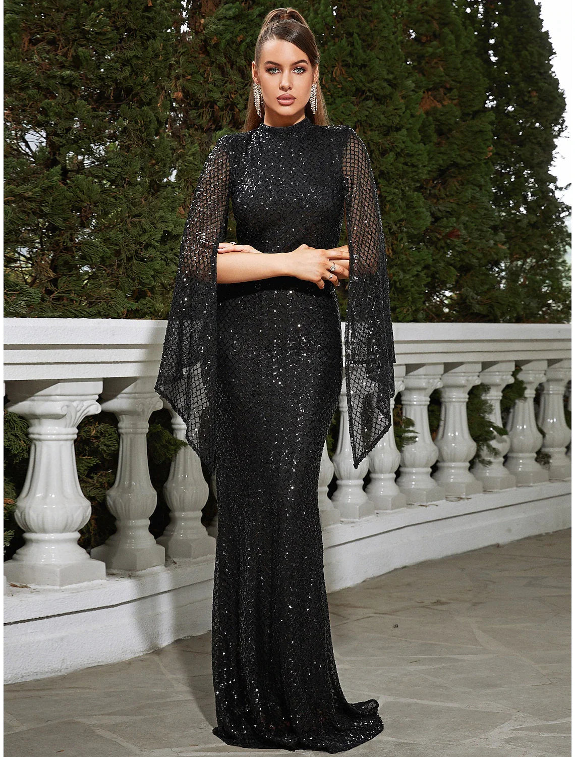 Woman wearing a dazzling sequined mermaid trumpet evening gown with a high neck and floor length.
