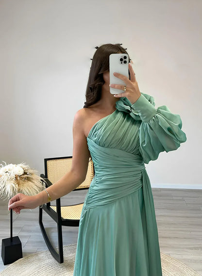 Side view of a model in a dusty teal A-line prom dress, highlighting the puff sleeve and ruched detailing.