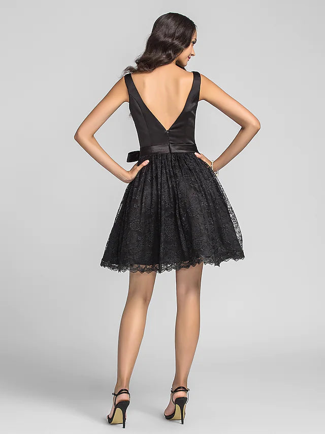 Close-up of the luxurious lace charmeuse fabric and delicate draping on the black tea length dress.