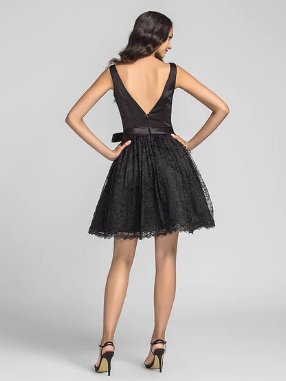 Close-up of the luxurious lace charmeuse fabric and delicate draping on the black tea length dress.
