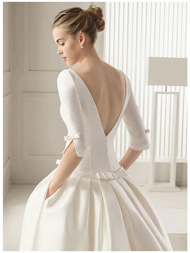 Back view of the white A-line wedding dress, showcasing the court train and half sleeves.