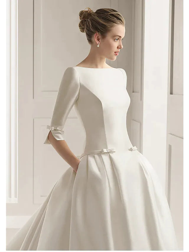 Back view of a plus size A-Line wedding dress with a court train and bateau neckline.