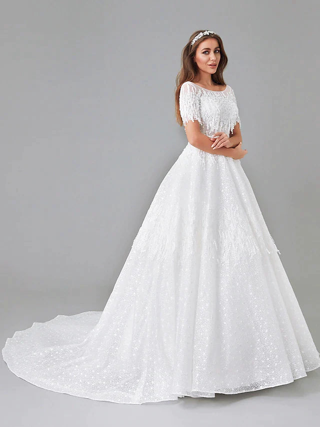 Detailed view of the intricate lace appliques and short sleeves on the wedding gown.
