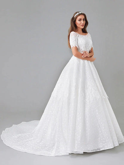 Detailed view of the intricate lace appliques and short sleeves on the wedding gown.
