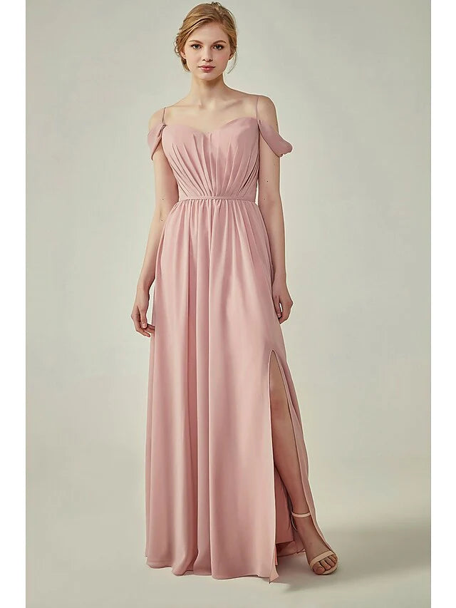 Woman wearing an A-Line chiffon bridesmaid dress with spaghetti straps, ruching, and a sash ribbon.