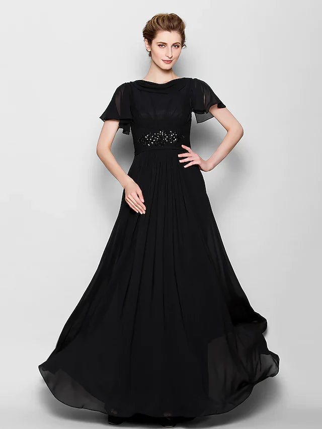 Woman wearing an elegant A-line mother of the bride dress with bateau neck and beading.