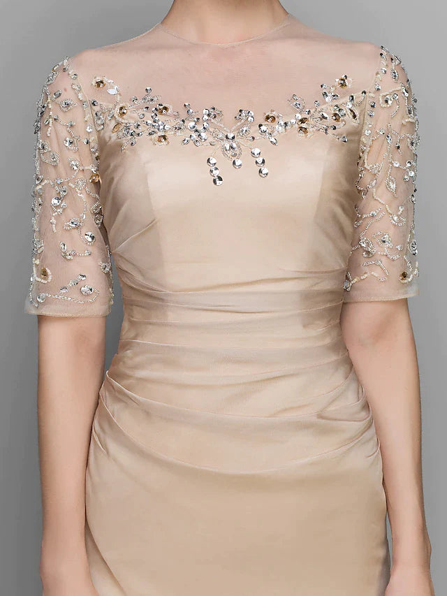 Close-up of the dress bodice with jewel neck, ruched detailing, and delicate beading.
