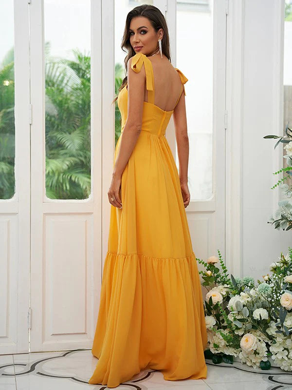 Back view of a woman in a light blue A-line chiffon bridesmaid dress with ruffled straps.