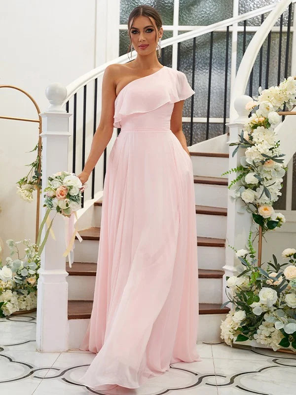 Woman wearing an elegant A-line one-shoulder chiffon bridesmaid dress with ruffles.