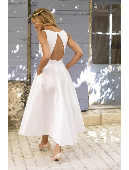 Woman in white A-line maxi dress, back view showcasing backless design.