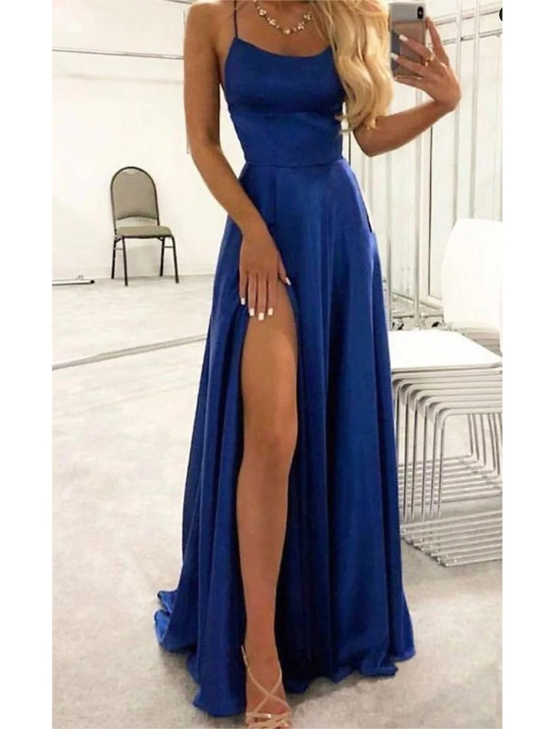 Elegant A-line empire evening gown with spaghetti straps, backless design, and high slit, featuring a court train.
