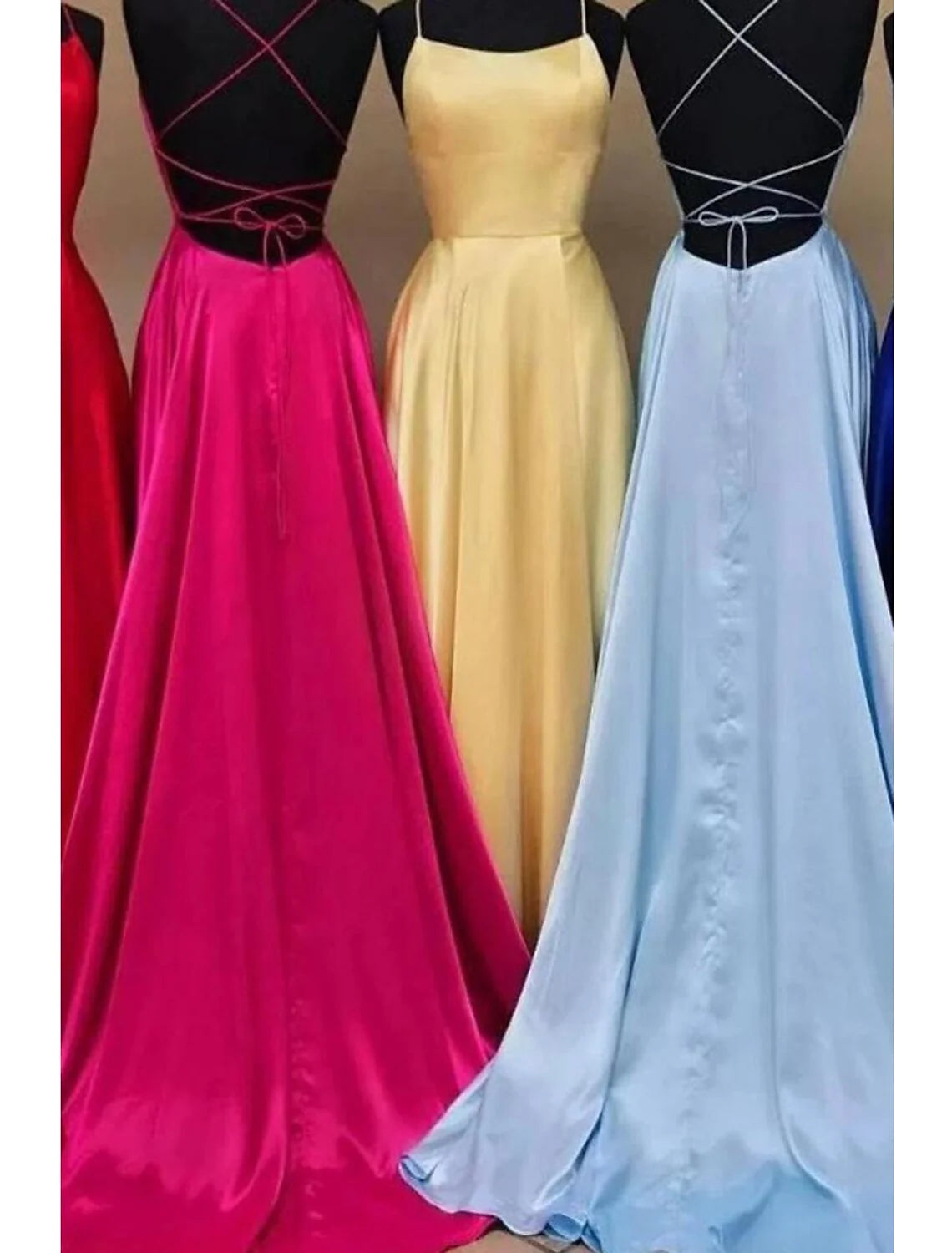 Model posing in the elegant A-line charmeuse gown, highlighting the backless detail and flowing skirt.