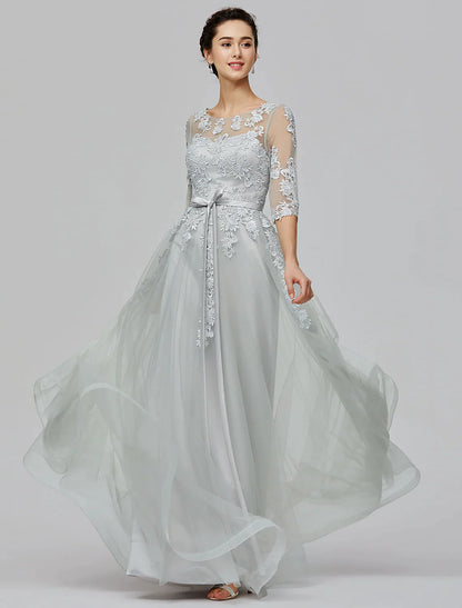 Back view of a woman wearing an A-Line Empire tulle dress, highlighting the illusion back and bow details.