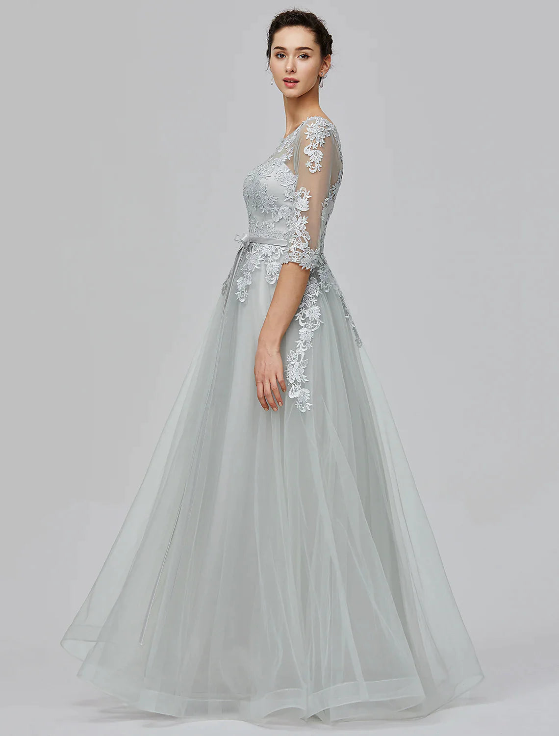 Woman in A-Line Empire tulle dress in a seated pose, highlighting the bodice and skirt.