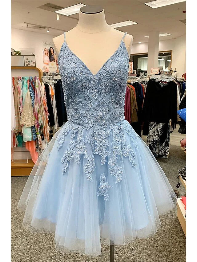 Model wearing an A-Line floral homecoming dress with spaghetti straps and appliques.