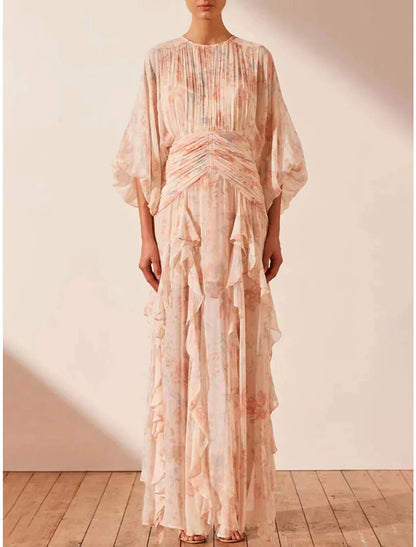 Woman wearing an elegant A-line floral maxi dress with long sleeves and ruffles.
