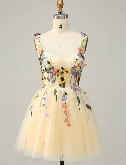 Model wearing an A-line floral tulle homecoming dress with spaghetti straps and appliques.