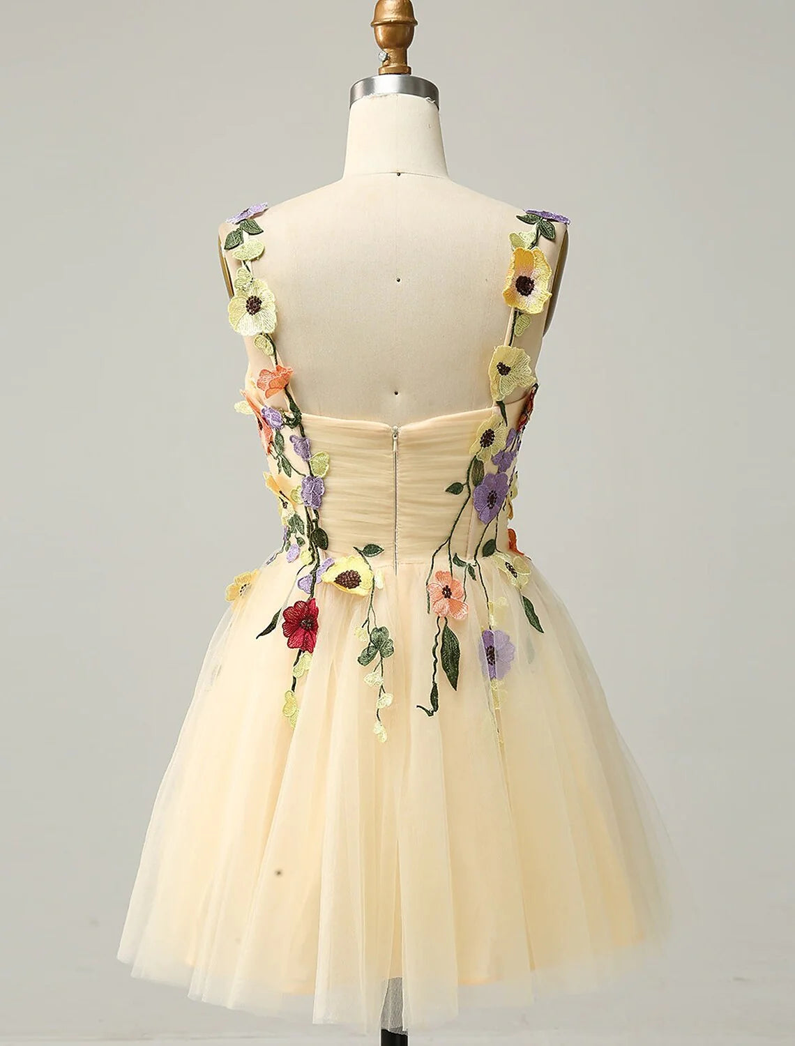 Back view of a model in a short A-line floral tulle cocktail dress.